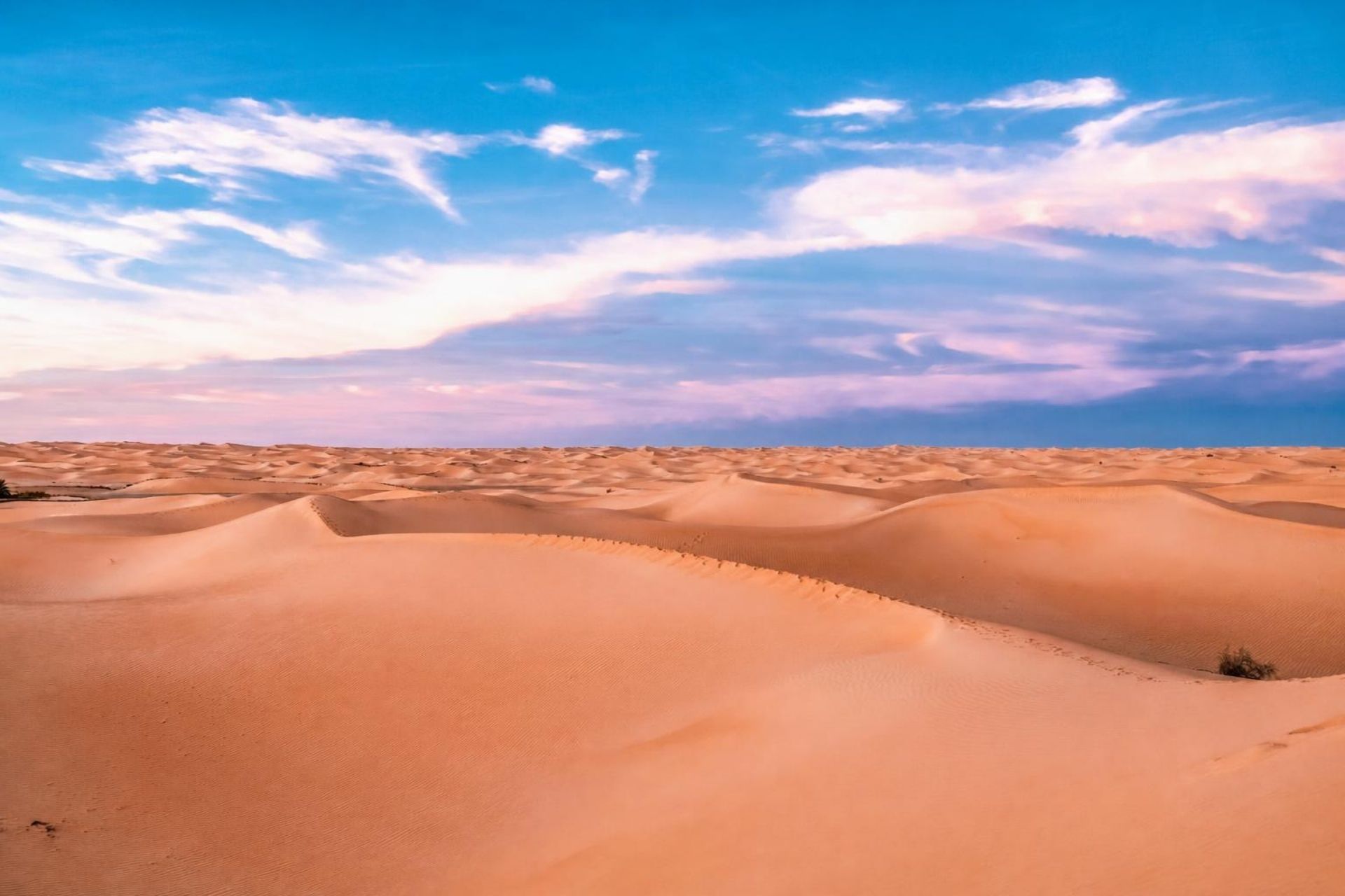 Golden dunes of Timimoun beneath a blue sky